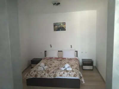 a bedroom with a bed with two teddy bears on it at Семеен Хотел Дани in Asenovgrad