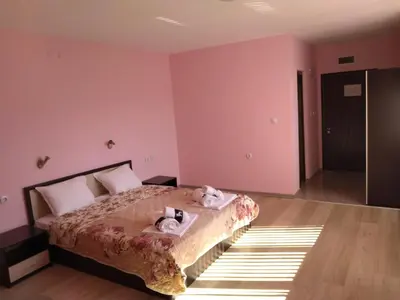 a bedroom with a bed with two stuffed animals on it at Семеен Хотел Дани in Asenovgrad