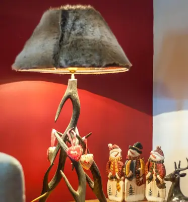 a lamp with a group of figurines next to a flower at Bansko Royal 721 Apartment in Bansko