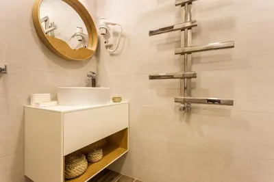 a bathroom with a white sink and a mirror at SCA Sofia City Apartments in Sofia