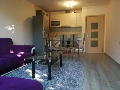 a living room with a purple couch and a table at Луксозен апартамент в идеалния център на град Сандански in Sandanski