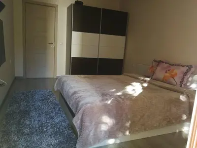 a bedroom with a bed and a blue rug at Луксозен апартамент в идеалния център на град Сандански in Sandanski