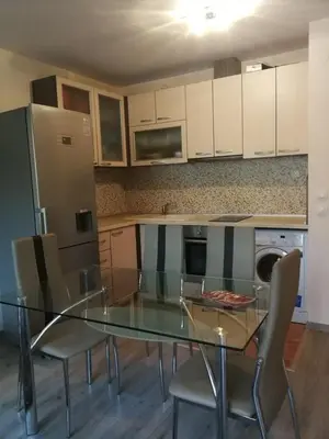 a kitchen with a glass table and chairs and a refrigerator at Луксозен апартамент в идеалния център на град Сандански in Sandanski