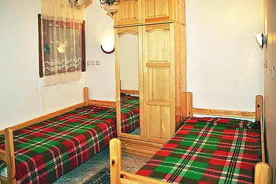 a bedroom with a bed and a wooden cabinet at Family hotel Zora in Sofia