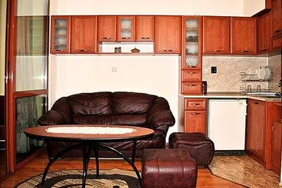 a kitchen with a leather chair and a table at Family hotel Zora in Sofia