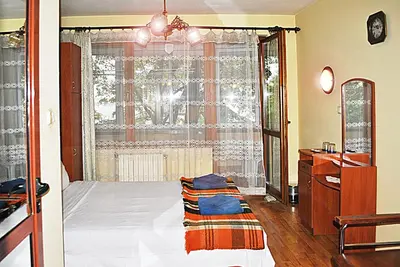 a bedroom with a bed and a large window at Family hotel Zora in Sofia