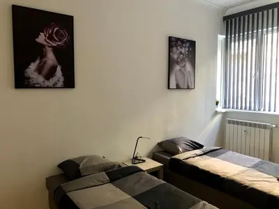 a room with two beds and a table and a window at Spacious modern vintage flat in the heart of Sofia in Sofia