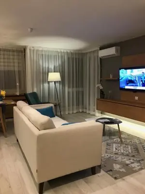 a living room with a white couch and a flat screen tv at Riverside apart in Blagoevgrad