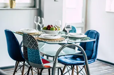 a glass table with chairs and a bowl of fruit on it at Gladstone suites in Plovdiv
