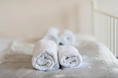 a pile of towels sitting on top of a bed at Gladstone suites in Plovdiv