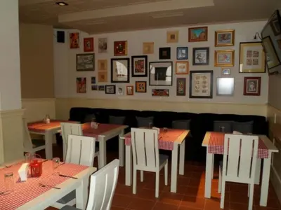 a restaurant with tables and chairs and pictures on the wall at Cedar Lodge in Bansko