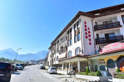 a building with a sign on the side of a street at Cedar Lodge in Bansko