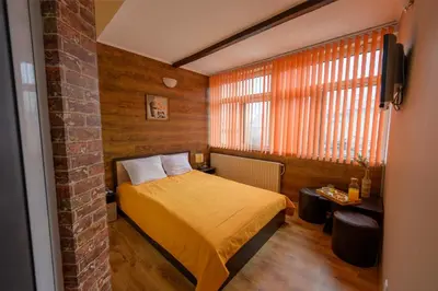 a small bedroom with a bed and a window at Ахат- къща за гости in Kyustendil