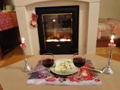 a table with a plate of food and two glasses of wine at Apartment Viki Pamporovo in Pamporovo