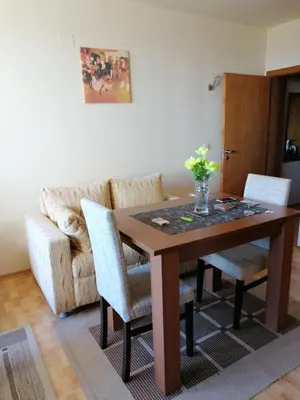 a dining room table with two chairs and a couch at Apartment Viki Pamporovo in Pamporovo