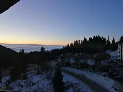 a view of a village in the snow at sunset at Apartment Viki Pamporovo in Pamporovo