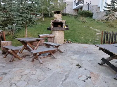 a picnic table and benches with a pizza oven at Apartment Viki Pamporovo in Pamporovo