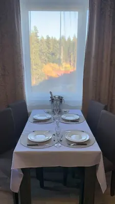 a table with plates and glasses on it with a window at ComfortApartment IGLIKA 2 in Borovets