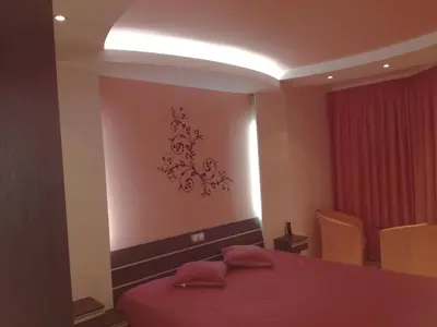 a bedroom with a bed with a red bedspread on it at Apartment 33 in Hotel Iceberg in Borovets