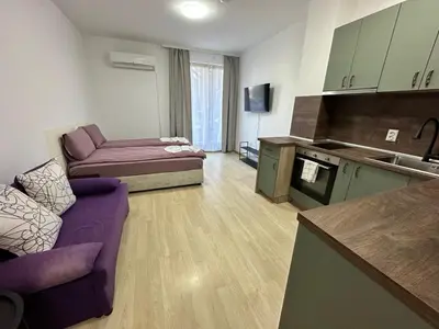 a living room with a purple couch and a kitchen at Luxury apartments in St. John Park in Bansko