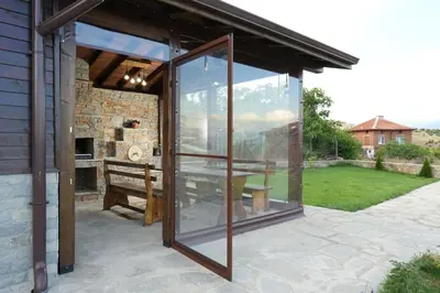 a glass pavilion with a table and a bench at Къща за гости Елица in Starchevo