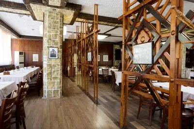 a dining room with white tables and wooden walls at Constantzia Balneohotel in Kostenets Village