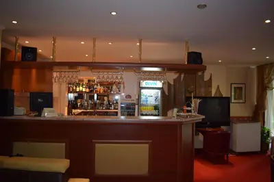a bar in a restaurant with a bar counter at Хотел 