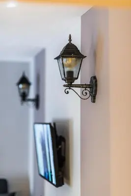 a light on the corner of a wall with a tv at The Red Roof House in Plovdiv