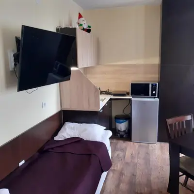 a small room with a bed and a desk with a television at Iglika 2, A6 in Borovets