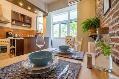 a kitchen with a table with bowls and wine glasses at FUNKY FRESH place in the heart of Sofia in Sofia