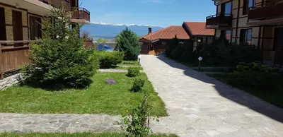 a walkway between two buildings with trees in a yard at Simon's studio in Bansko