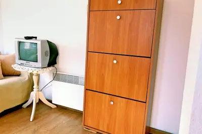 a wooden dresser with a television in a room at Нouse with cute little yard in Plovdiv