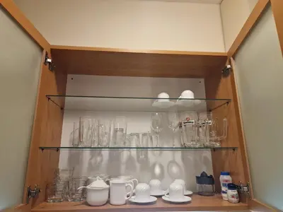 a cupboard filled with glasses and other items at Flora Apartments TMF in Borovets