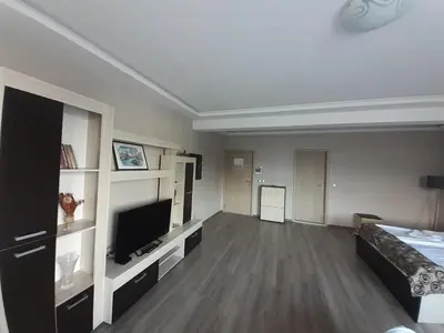 a living room with a bed and a flat screen tv at Alexander Hotel in Asenovgrad