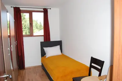 a bedroom with a bed with a yellow blanket and a window at Vidima Apartment Hotel in Apriltsi