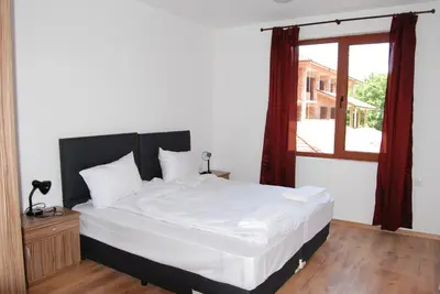 a bedroom with a large white bed with a window at Vidima Apartment Hotel in Apriltsi