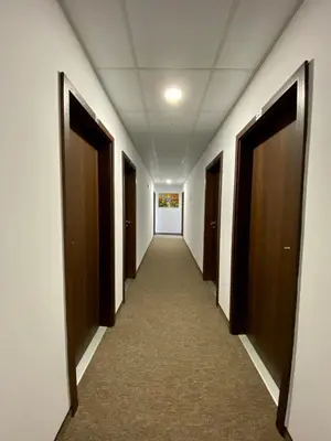 a hallway of an office building with brown doors at Edelweiss Central Hotel in Bansko