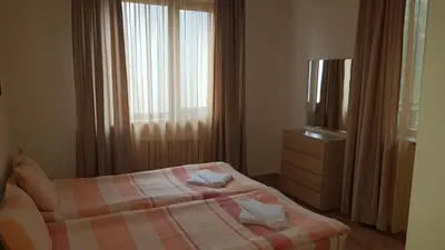 a bedroom with a bed and a tv and a window at Borovets Gardens Apartments TMF in Borovets