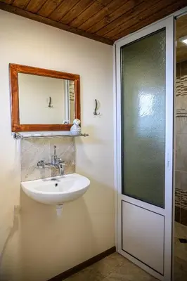 a bathroom with a sink and a mirror and a shower at Medi Guest House in Sapareva Banya