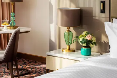 a hotel room with a bed and a table with a lamp at Grand Hotel Millennium Sofia in Sofia
