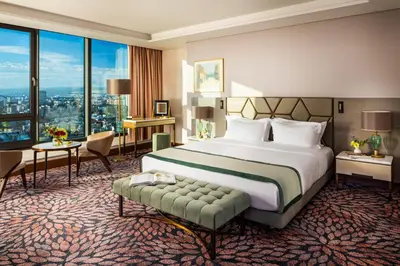 a hotel room with a bed and a large window at Grand Hotel Millennium Sofia in Sofia
