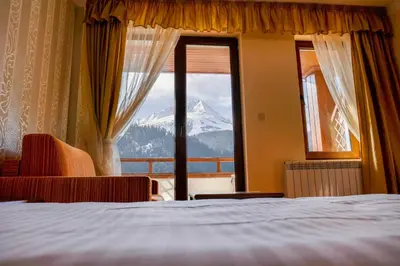 a bedroom with a view of a mountain from a window at Park Hotel Panorama in Bansko