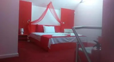 a red bedroom with a bed with a red headboard at Бора Бора in Sapareva Banya