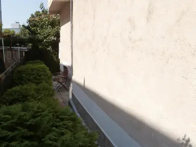 a wall with a row of plants next to a building at Apartments in House Silent Nature in Sandanski