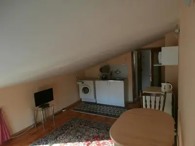 a living room with a table and a kitchen at Apartments in House Silent Nature in Sandanski