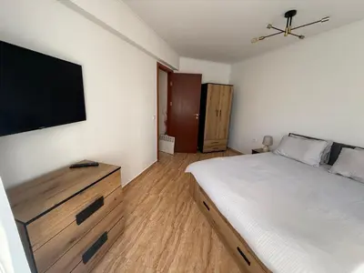 a bedroom with a bed and a flat screen tv at Пампорово , Манастира 3 in Pamporovo