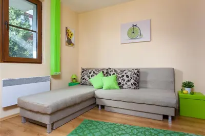 a living room with a couch and a chair at Green Lime Studio in Bansko