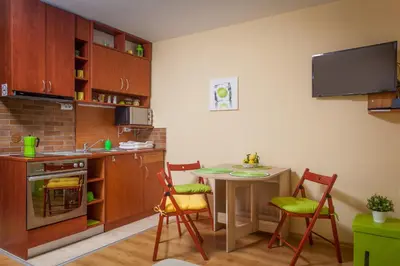 a kitchen with a table and chairs and a kitchen with a sink at Green Lime Studio in Bansko