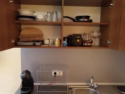 a kitchen with a sink and a shelf with dishes at Studio Villa Park 207 in Borovets