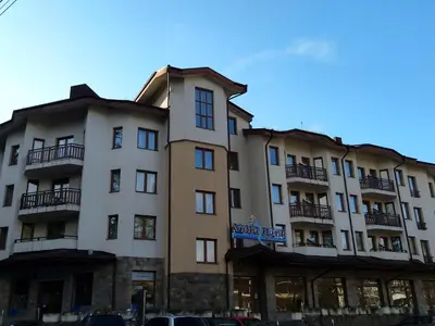 a large building with cars parked in front of it at Studio Villa Park 207 in Borovets